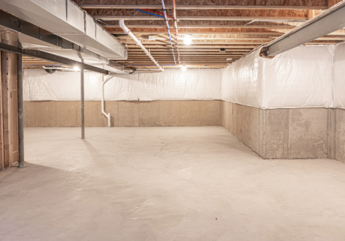 Finished basement with waterproofed walls and sealed floors, showcasing clean and protected concrete surfaces.