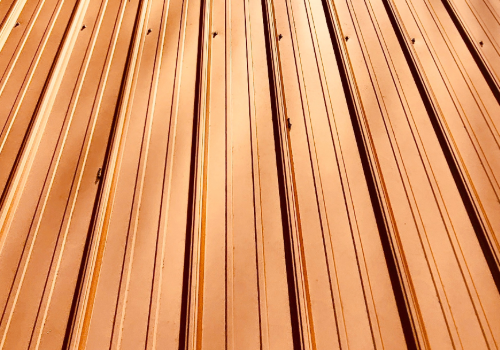 Textured close-up of a copper roof highlighting the unique patina and craftsmanship.