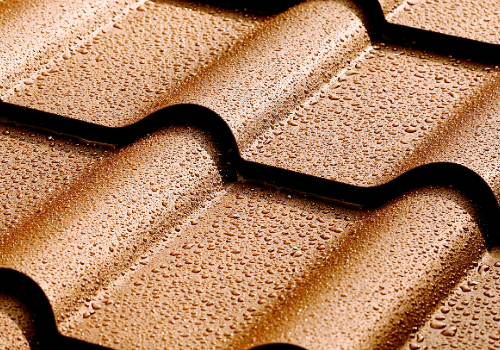 Close-up of wet steel shingles with droplets, showcasing the texture and quality.