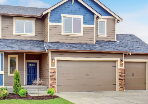 Elegant two-story residential home with a newly installed blue shingle roof and dual garage doors.